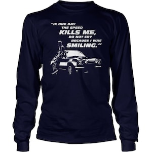 May include: A navy blue long-sleeve t-shirt with a white graphic of a man standing next to a black car. The text on the shirt reads "IF ONE DAY THE SPEED KILLS ME, DO NOT CRY BECAUSE I WAS SMILING."