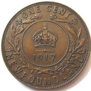 May include: A copper-colored Newfoundland one-cent coin from 1917. The coin features a crown, floral designs, and the text "ONE CENT" and "NEWFOUNDLAND". The coin is round with a detailed design.