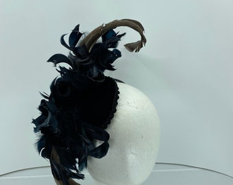 May include: A black velvet hat with a large black feather plume and a brown feather accent.