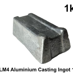 May include: A rectangular LM4 aluminum casting ingot weighing 1kg. The metal block has a textured, matte grey surface with a central longitudinal groove. The text "BLACK BARN DESIGN" appears vertically on the left, and "1kg" is printed in the top right corner.