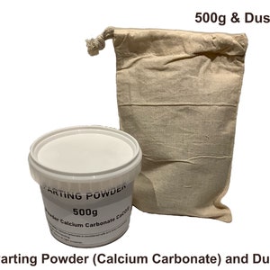 Puede incluir: Un recipiente de plástico blanco con 500 g de polvo desmoldeante, etiquetado como "Parting Powder (Calcium Carbonate)", junto a una bolsa de polvo beige. El texto "500g & Dust Bag" está encima de la bolsa. La marca "BLACK BARN DESIGN" está a la izquierda.