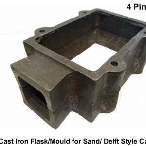 May include: A cast iron flask or mold for sand or Delft style casting. The rectangular mold has a dark gray, textured finish with a 4-pin type design. The text "4 Pin Type" is visible.