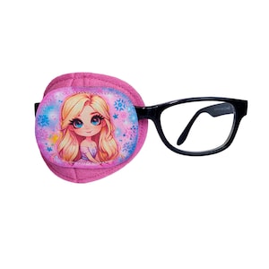 Puede incluir: Parche para el ojo rosa con una niña de dibujos animados con cabello rubio y ojos azules sobre un fondo rosa y azul. El parche está unido a un par de gafas con montura negra.