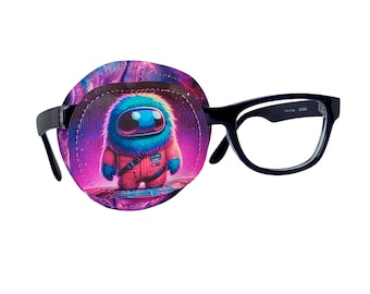May include: A purple and pink eye patch with a cartoon astronaut wearing a red spacesuit and a blue fuzzy head. The eye patch is attached to a pair of black framed glasses.