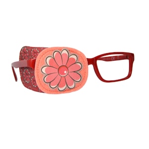 May include: Red eye patch with a pink flower design. The eye patch is attached to a pair of red plastic framed glasses.