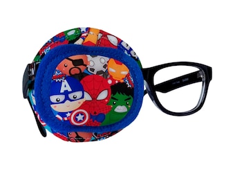 May include: A blue eye patch with a superhero theme featuring characters like Spiderman, Captain America, and Hulk. The patch is attached to a pair of black framed glasses.