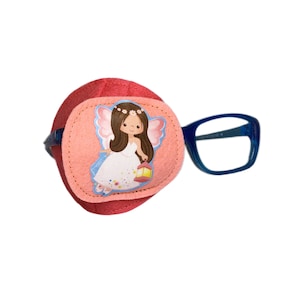Puede incluir: Parche para el ojo de fieltro rosa con una imagen impresa de una niña hada con cabello castaño y un vestido blanco que sostiene una linterna. El parche para el ojo está unido a un marco de plástico azul.