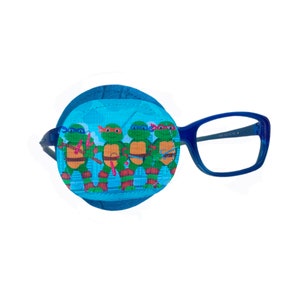 Peut inclure: Un cache-œil bleu avec un motif des Tortues Ninja. Le cache-œil est fait de tissu doux et a une fermeture velcro. Le cache-œil est associé à des lunettes à monture bleue.