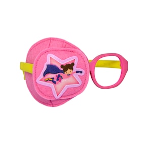 May include: Pink eye patch with a yellow elastic band and a pink and yellow plastic frame. The eye patch has a star with a superhero girl graphic on it.