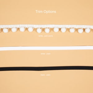 May include: Three trim options for a garment: white trim with pom poms, white plain trim, and black plain trim.