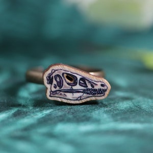 Ring with wooden Velociraptor skull charm
