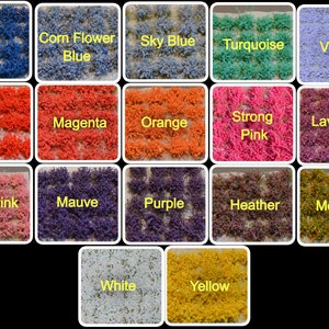 May include: A collection of 16 different coloured artificial grass samples, each labelled with its colour name. The colours include blue, cornflower blue, sky blue, turquoise, violet, red, magenta, orange, strong pink, lavender, lilac pink, mauve, purple, heather, meadow, white, and yellow.