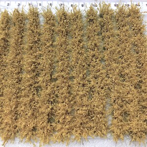 May include: A sheet of light brown, dry, static grass tufts, arranged in rows. The grass is approximately 1 inch in length.