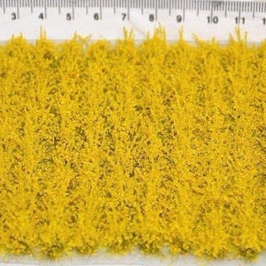 May include: A sheet of yellow static grass for model railroading or miniature gaming. The grass is approximately 14 inches long and is shown next to a ruler.
