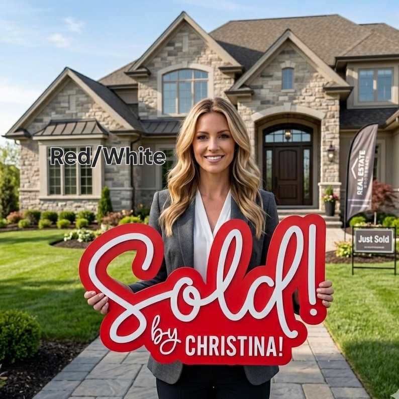 May include: A woman holding a large red and white "Sold!" sign in front of a house. The sign has white cursive lettering that reads "Sold by Christina!". A "Just Sold" sign is in the background.