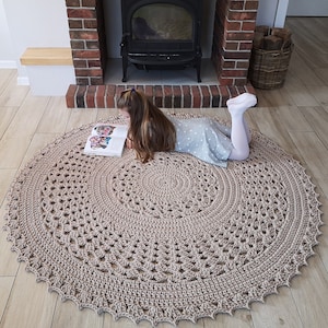 Tapis ajouré beige rond au crochet.