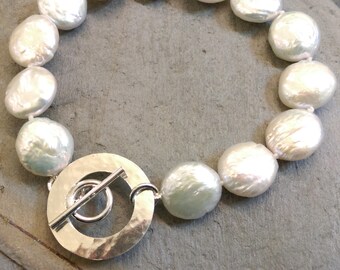 Contemporary white coin pearl bracelet with distinctive handmade hammered silver circle toggle fastening. Spring bride. Wedding. Bridal.