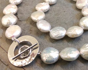 Contemporary white coin pearl necklace with distinctive handmade hammered silver circle toggle fastening. Spring bride. Wedding. Bridal.