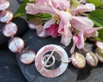 Contemporary pink coin pearl necklace with distinctive handmade hammered silver circle toggle fastening. June birthstone