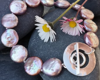 Contemporary pink coin pearl bracelet with distinctive handmade hammered silver circle toggle fastening. Spring gift.