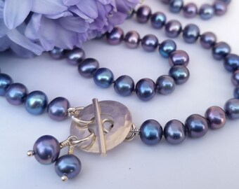 Handmade contemporary cornflower blue freshwater pearl necklace with hammered silver circle toggle fastening. June birthstone. 30th Wedding.