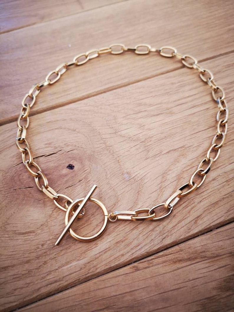 Puede incluir: Un collar de cadena dorada con cierre de palanca. La cadena est&aacute; hecha de eslabones ovalados.