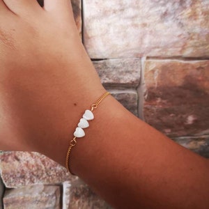 Thin gold bracelet with mother-of-pearl hearts