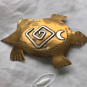Silver and copper turtle brooch with symbols