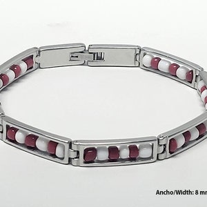 May include: A stainless steel bracelet with alternating red and white beads. The bracelet is 8 mm (0.31 inches) wide.