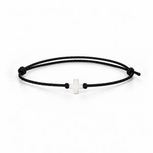 Puede incluir: Una pulsera de cordón negro con un pequeño dije de cruz en tono plateado pulido centrado en el hilo. La pulsera incluye dos nudos deslizantes ajustables a cada lado de la cruz, lo que permite un ajuste flexible alrededor de la muñeca.