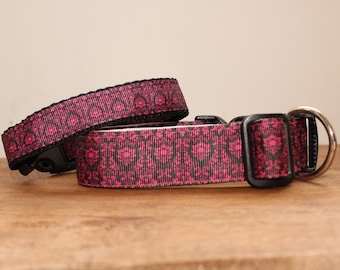 May include: Two pink and black patterned dog collars with black plastic buckles and a silver metal D-ring.