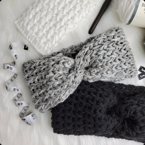 May include: Three crocheted headbands in white, gray, and black. The headbands are made with a chunky yarn and have a twisted knot design.