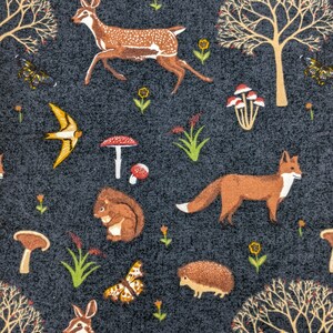 May include: A fabric with a dark gray background featuring a repeating pattern of woodland creatures and elements. The design includes deer, foxes, squirrels, butterflies, mushrooms, trees, and flowers in shades of brown, orange, yellow, and white.
