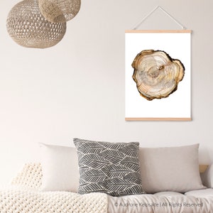 May include: A close-up of a wood slice with visible rings. The wood slice is light brown with darker brown rings. The wood slice is on a white background.