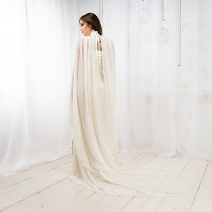 May include: A white wedding dress with a long, flowing train and a lace-up corset back.