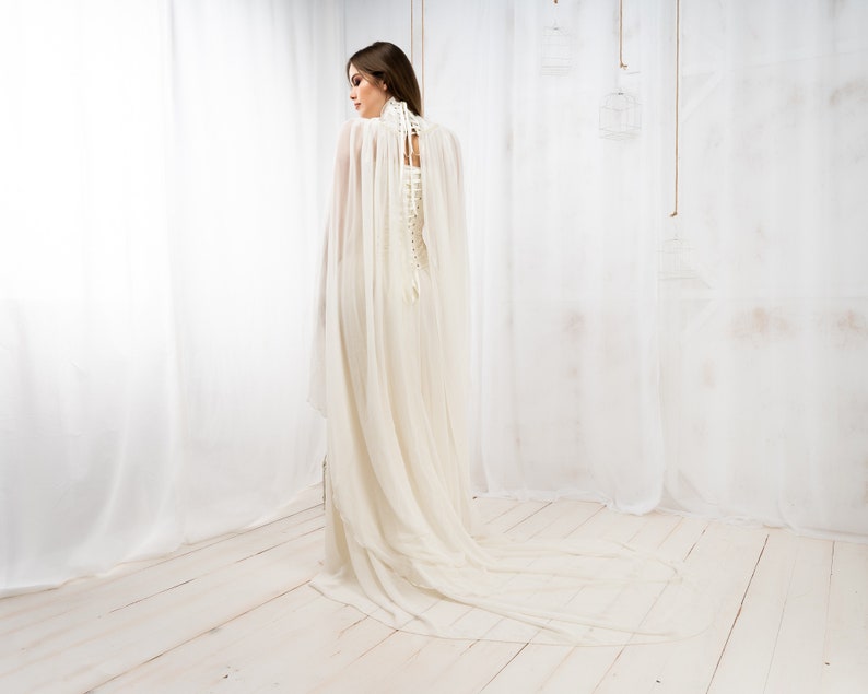 May include: A white wedding dress with a long, flowing train and a lace-up corset back.