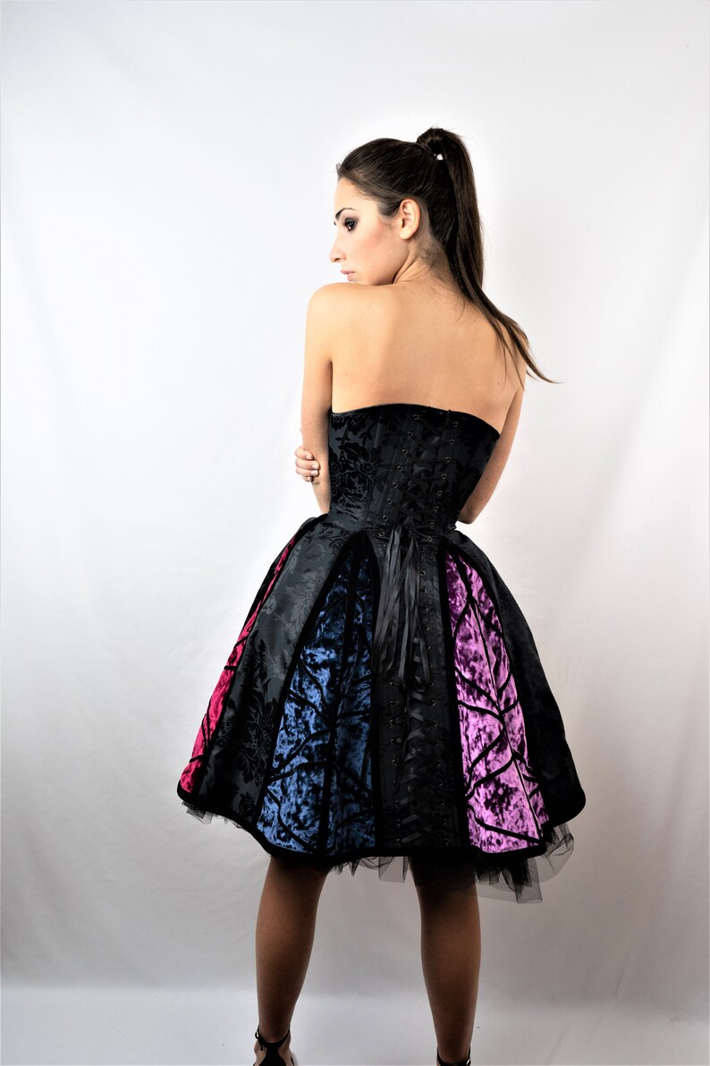 May include: A black strapless dress with a fitted bodice and a full skirt. The skirt is made of different colored fabrics, including black, blue, and pink.