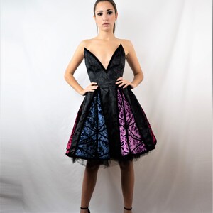 May include: A black strapless dress with a sweetheart neckline and a multi-colored velvet skirt. The skirt has panels of blue, pink, and black velvet.