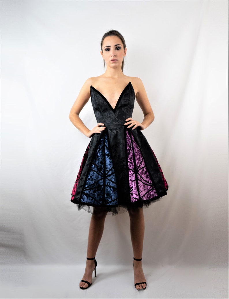 May include: A black strapless dress with a sweetheart neckline and a multi-colored velvet skirt. The skirt has panels of blue, pink, and black velvet.