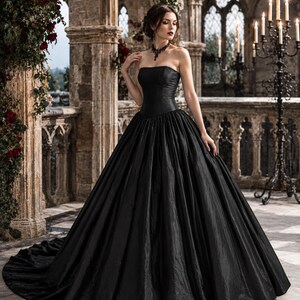 May include: A floor-length strapless black ball gown featuring a fitted bodice and a voluminous, full-length skirt with a train. The fabric has a subtle, textured sheen, and the garment is paired with a dark, intricate lace choker necklace.