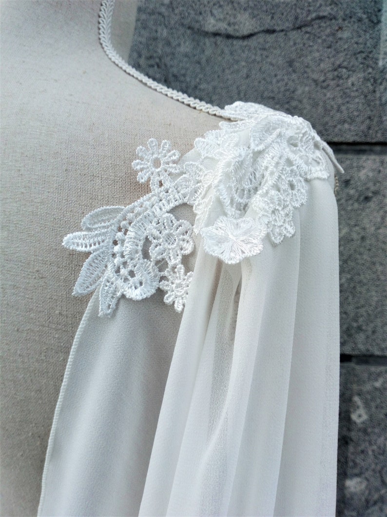Pu&ograve; includere: Tessuto bianco trasparente con un delicato bordo in pizzo. Il pizzo &egrave; un motivo floreale di colore bianco.