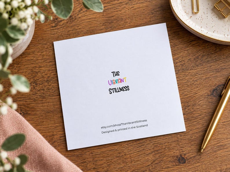 May include: A square white greeting card featuring the text The Vibrant Stillness in black, with the word Vibrant in multicolored letters. Below, the text reads etsy.com/shop/TheVibrantStillness and Designed & printed in the Scotland.