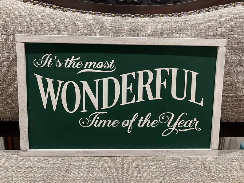 Puede incluir: Se&ntilde;al verde con marco blanco y el texto "It's the most WONDERFUL Time of the Year" en letras blancas.