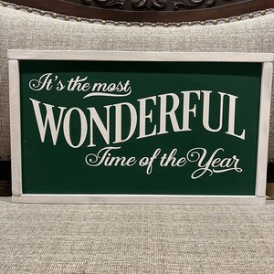 Puede incluir: Un letrero de madera verde con letras blancas que dice "It's the most WONDERFUL Time of the Year".