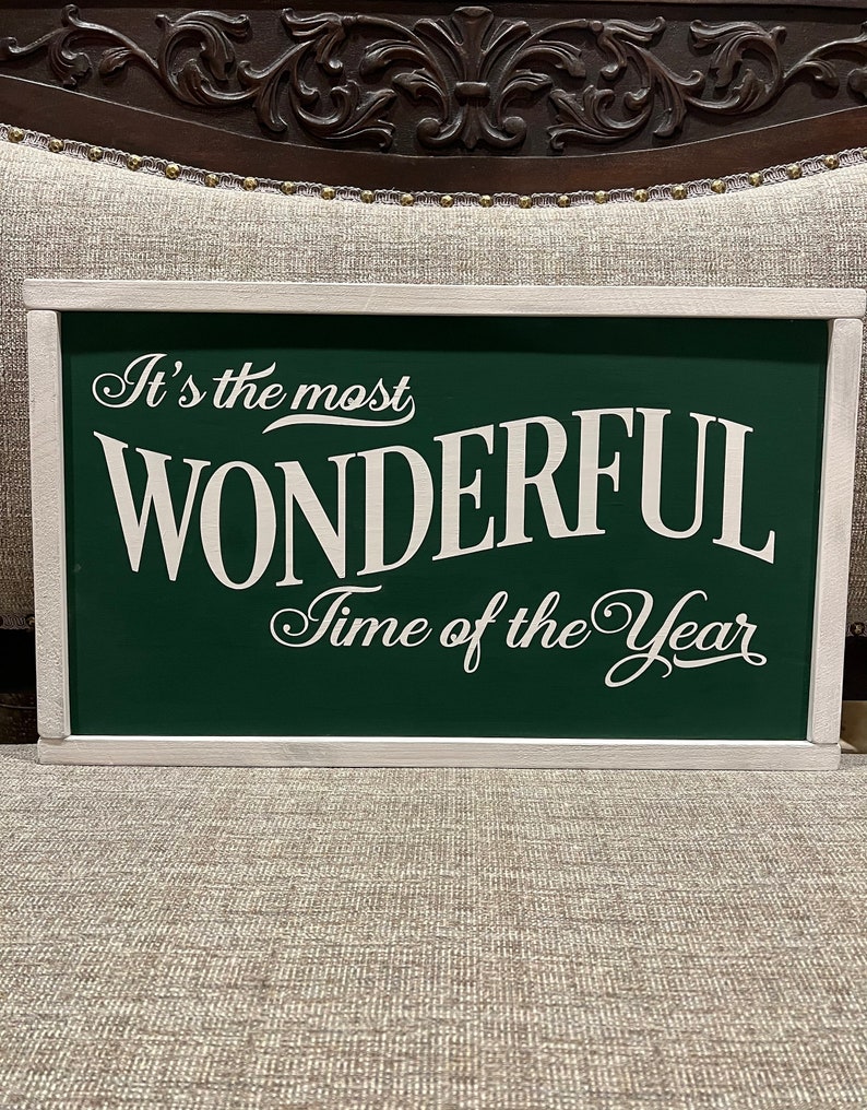 Puede incluir: Un letrero de madera verde con letras blancas que dice "It's the most WONDERFUL Time of the Year".