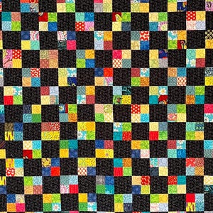 May include: A handmade quilt with a checkerboard pattern. The quilt features alternating black squares and squares with colorful patchwork designs. A light blue border surrounds the patchwork, and a black border frames the quilt. The quilt is likely made of cotton.