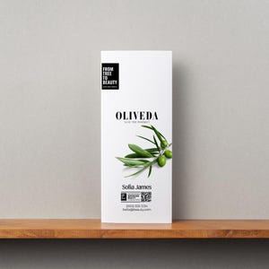 May include: A white brochure with the text "FROM TREE TO BEAUTY" and "OLIVEDA OLIVE TREE PHARMACY". It features a green olive branch with olives. The brochure also includes the name "Sofia James" and contact information.