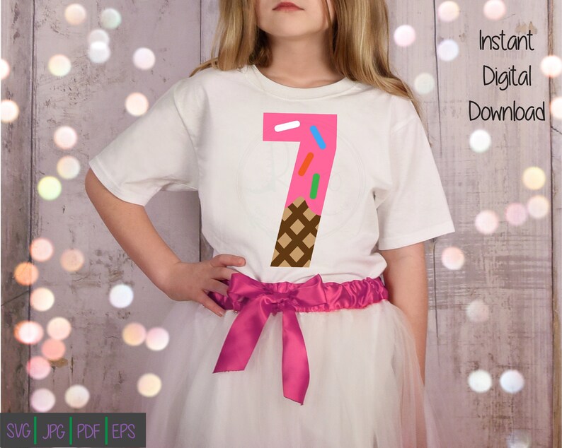 Peut inclure: Un t-shirt blanc avec un num&eacute;ro sept rose en forme de cornet de glace avec un c&ocirc;ne gaufr&eacute; brun et des p&eacute;pites color&eacute;es. Le t-shirt est port&eacute; par un enfant avec une jupe en tulle rose.