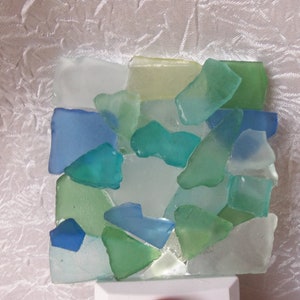 K&ouml;nnte beinhalten: Ein Nachtlicht aus Meerglas in Blaut&ouml;nen, Gr&uuml;n und Wei&szlig;. Die Glasst&uuml;cke sind in einem Mosaikmuster angeordnet.