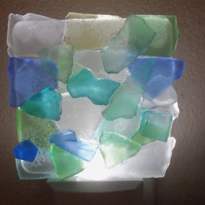K&ouml;nnte beinhalten: Ein Nachtlicht aus Meerglas in Blaut&ouml;nen, Gr&uuml;n und Wei&szlig;. Die Glassplitter sind in einem Mosaikmuster angeordnet.